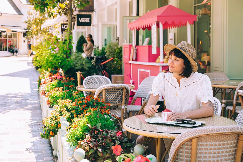 a woman sitting at a table outside