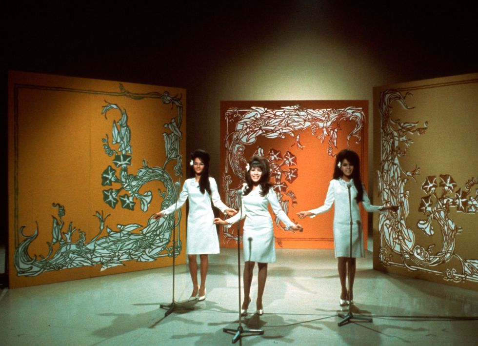 a group of women in white dresses performing onstage