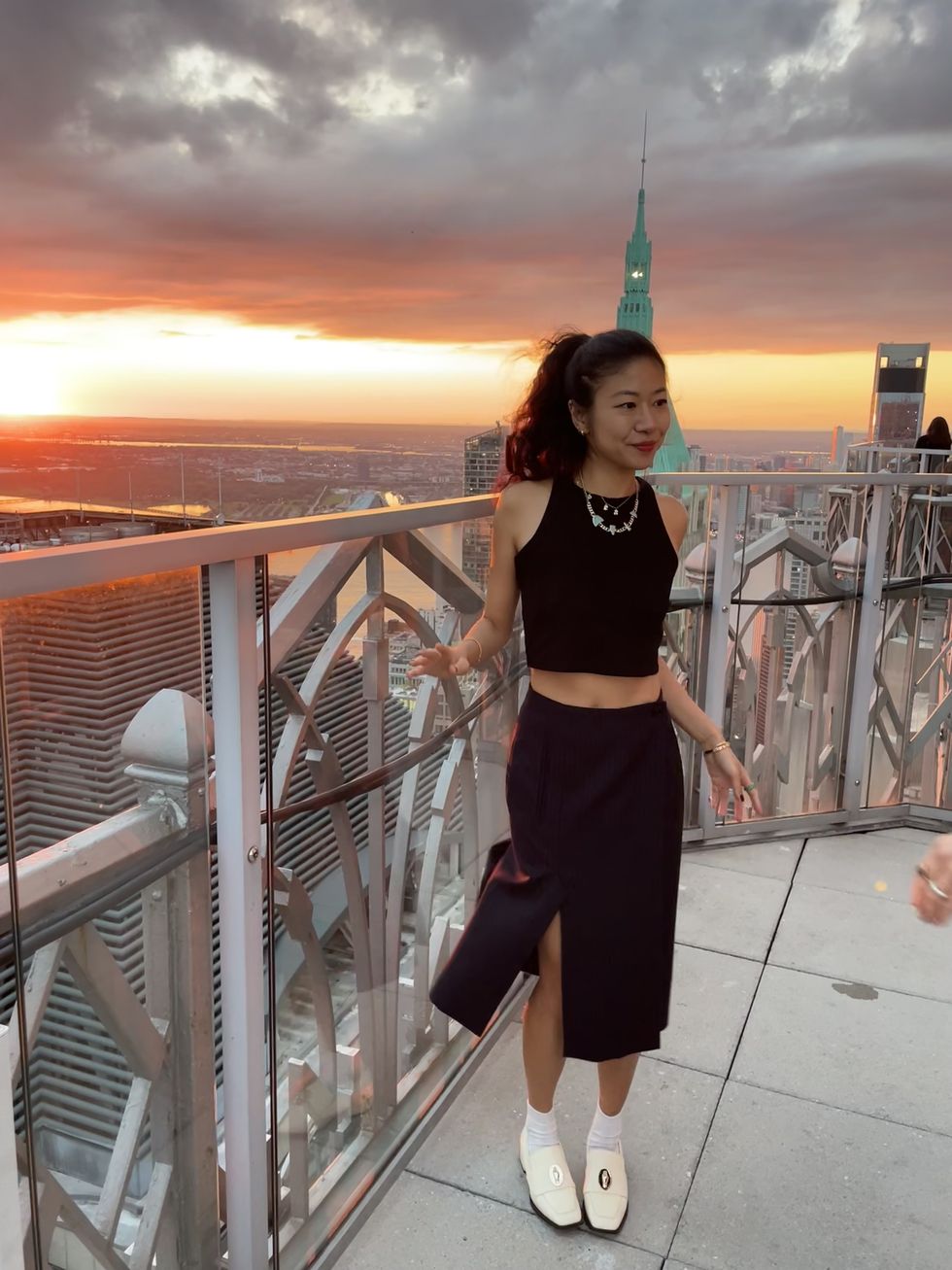 the author posing in a black crop top and midi skirt