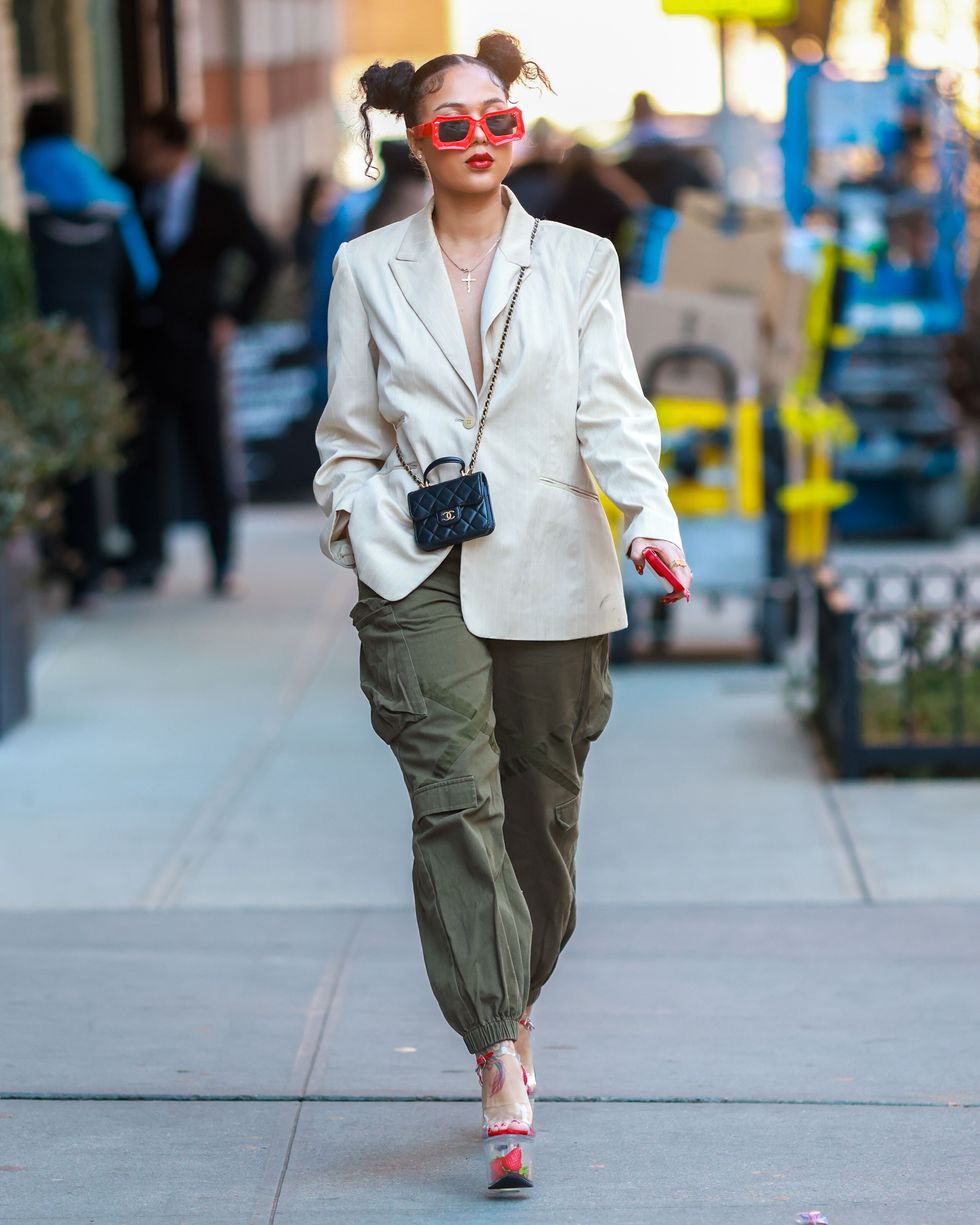 a woman wearing red sunglasses, a blazer and cargo pants