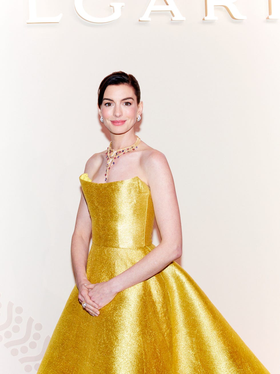 a woman in a yellow gown posing at an event