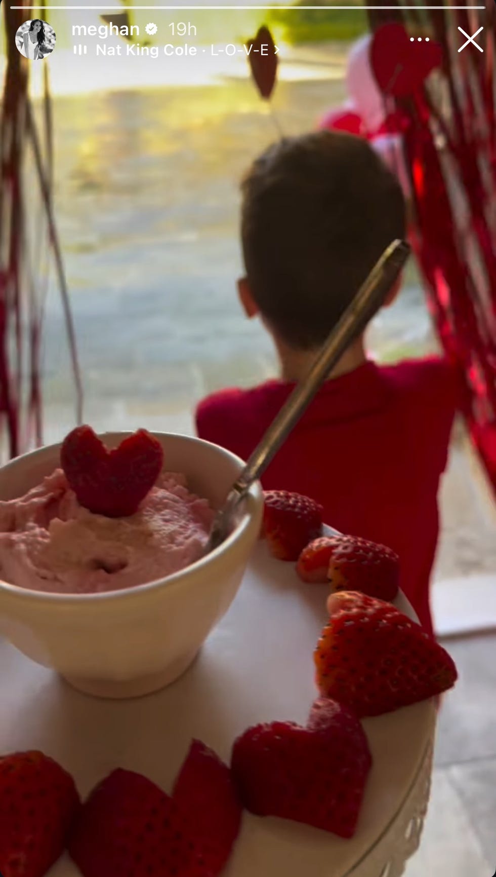 dessert with heartshaped strawberries and a child in the background