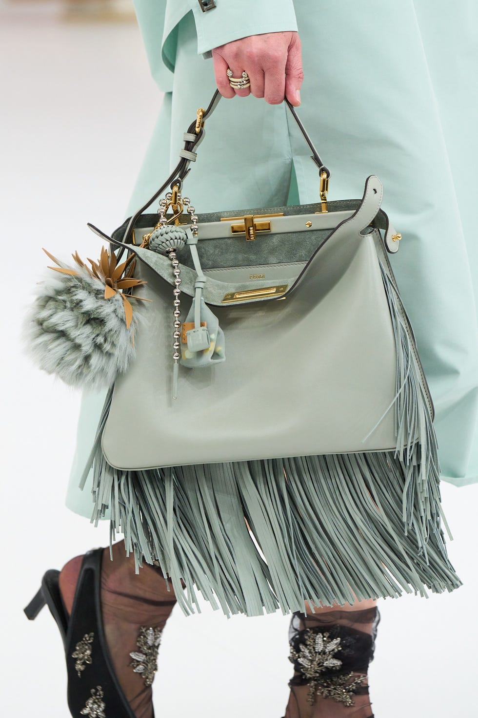 fringe handbag with embellishments held by a model