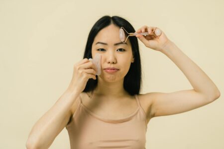 How Gua Sha Tools Made from Recycled Ocean Plastic Are Transforming Skincare Routines Close-up of hands holding a curved facial massage tool during a skincare routine