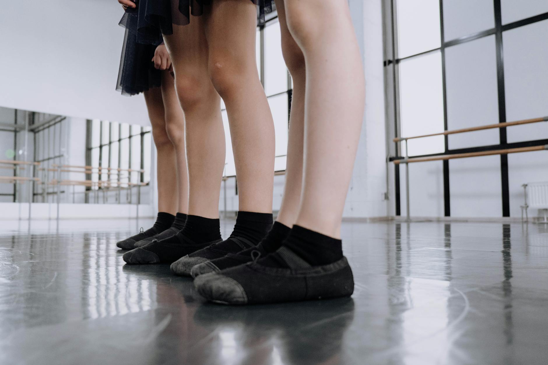 Professional ballet flats in black leather arranged on white background