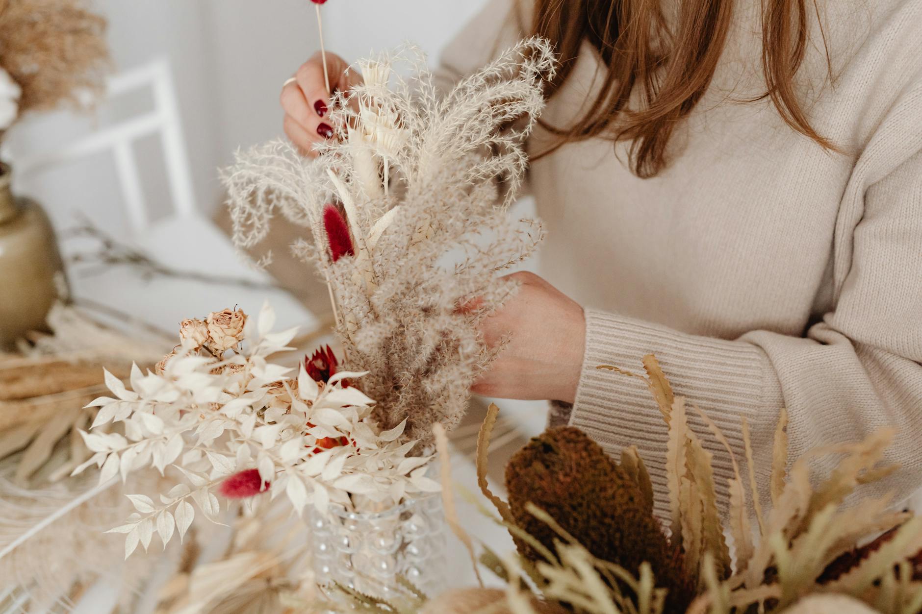 Elegant dried flower arrangement with pampas grass and preserved roses on rustic wooden table