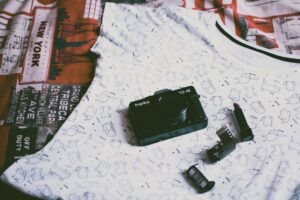 Why Gen Z Is Choosing Vintage Polaroid Cameras as Fashion Accessories Person holding vintage instant camera as fashion accessory