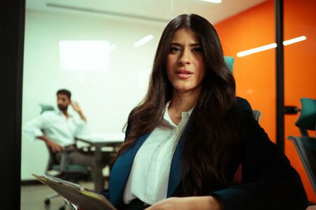 Professional woman wearing glasses and cardigan in modern office setting