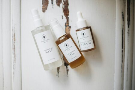 Clean white skincare product bottles arranged on minimalist surface