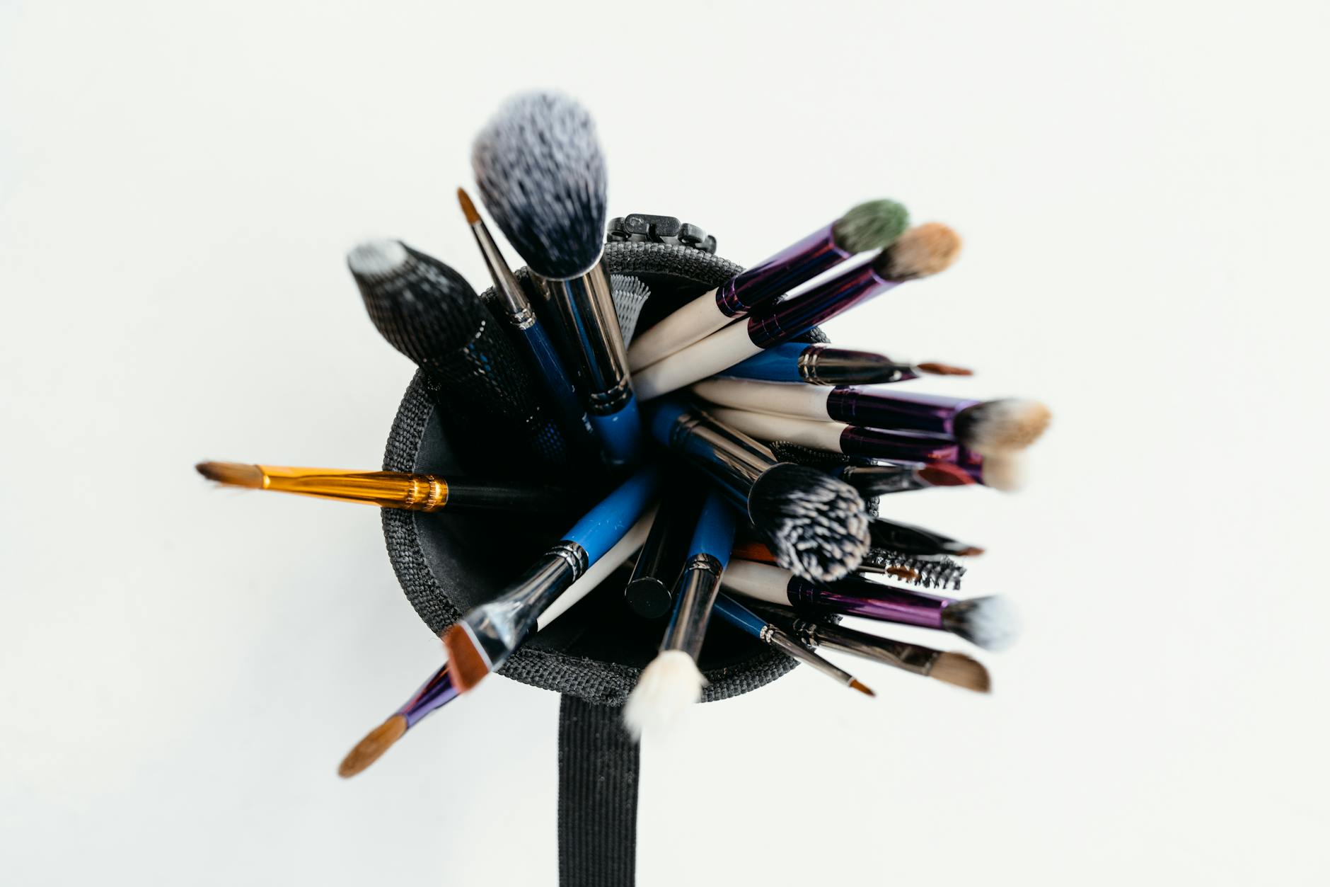 Professional makeup brushes and colorful cosmetics arranged on a clean surface