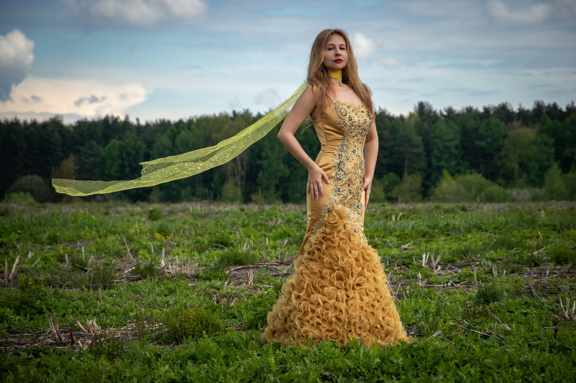 Model wearing elegant evening gown on fashion runway with dramatic lighting