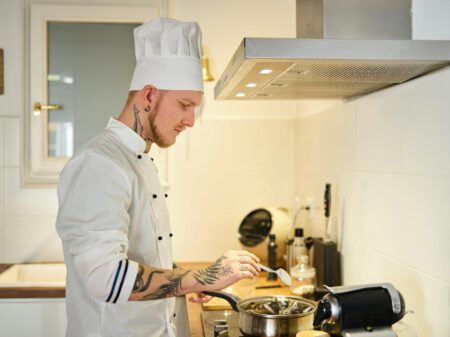 Professional chef wearing modern white uniform in commercial kitchen