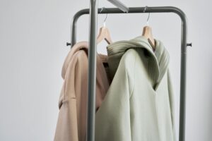 Neutral colored clothing pieces arranged minimally on hangers representing monastery-inspired fashion