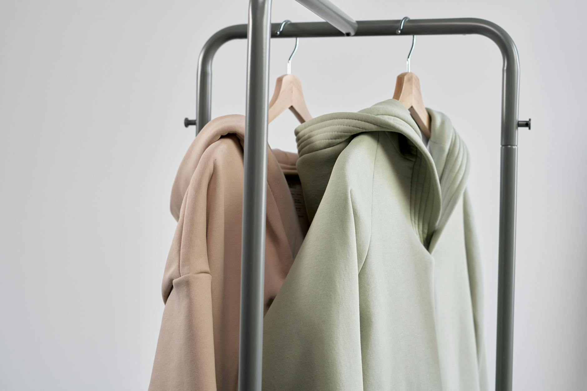 Neutral colored clothing pieces arranged minimally on hangers representing monastery-inspired fashion