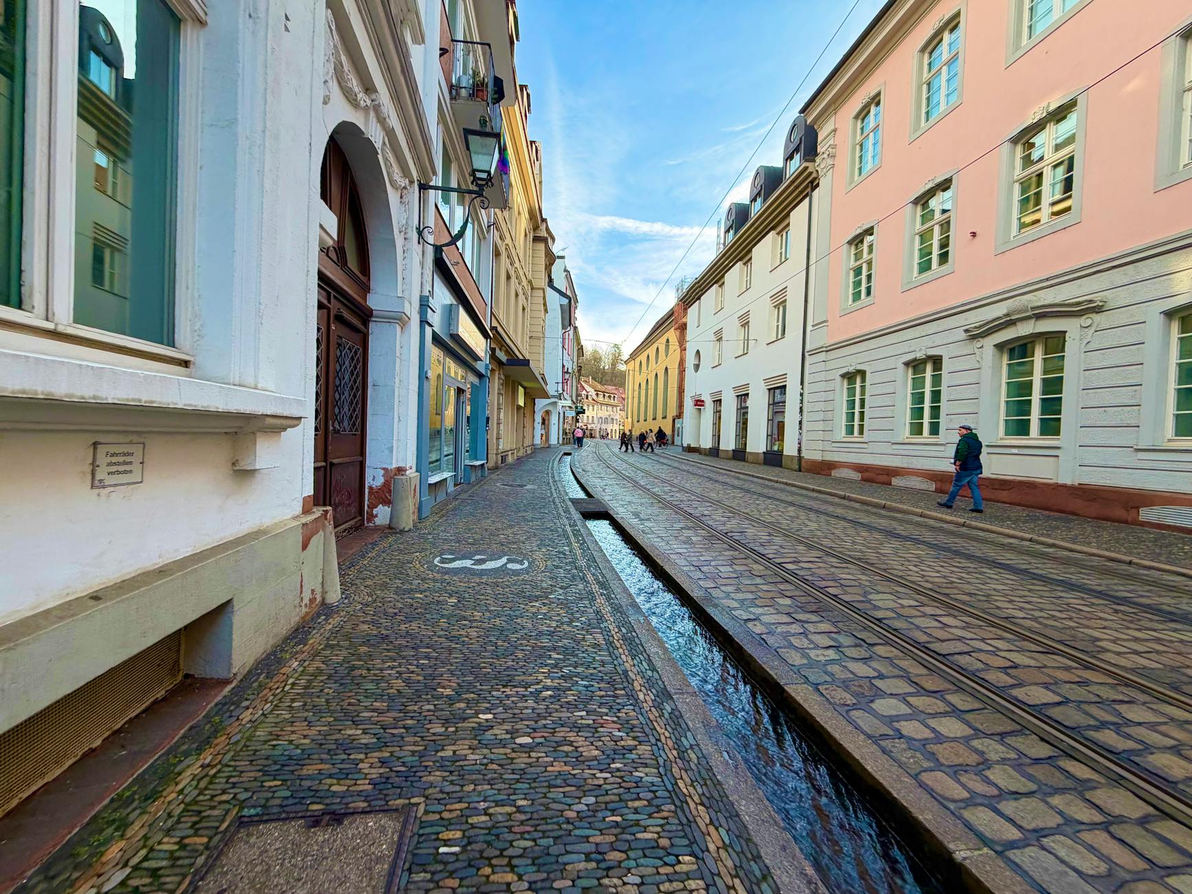 Person's feet walking on historic cobblestone street showing the challenging surfaces of fashion districts
