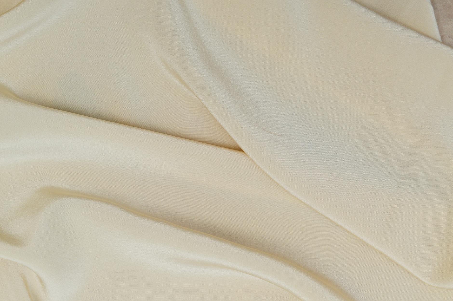 Close-up of luxurious silk fabric showing texture and sheen, representing premium materials used in high-end accessories