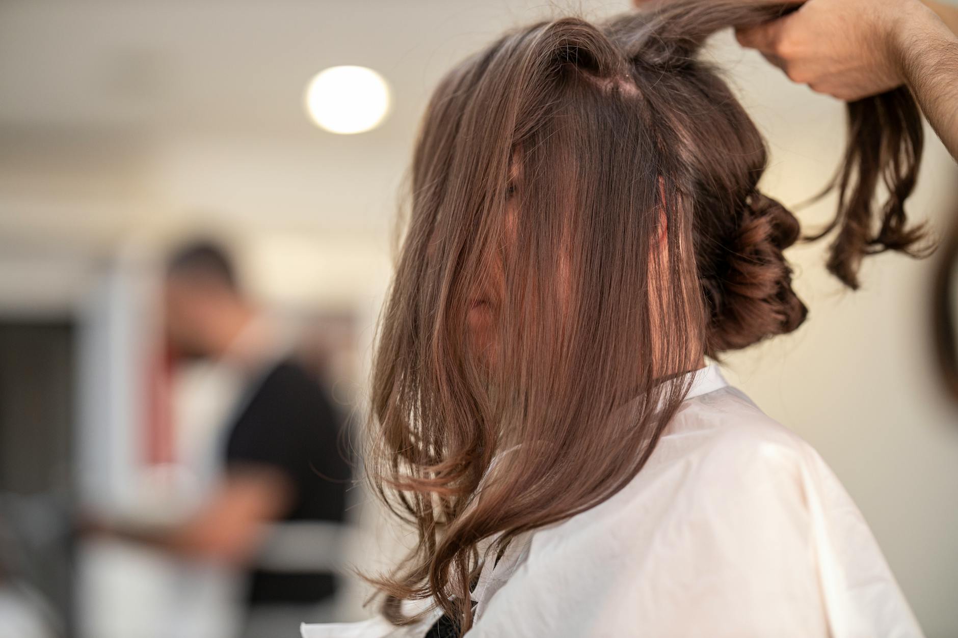 Young woman styling her hair with decorative hair accessories in mirror