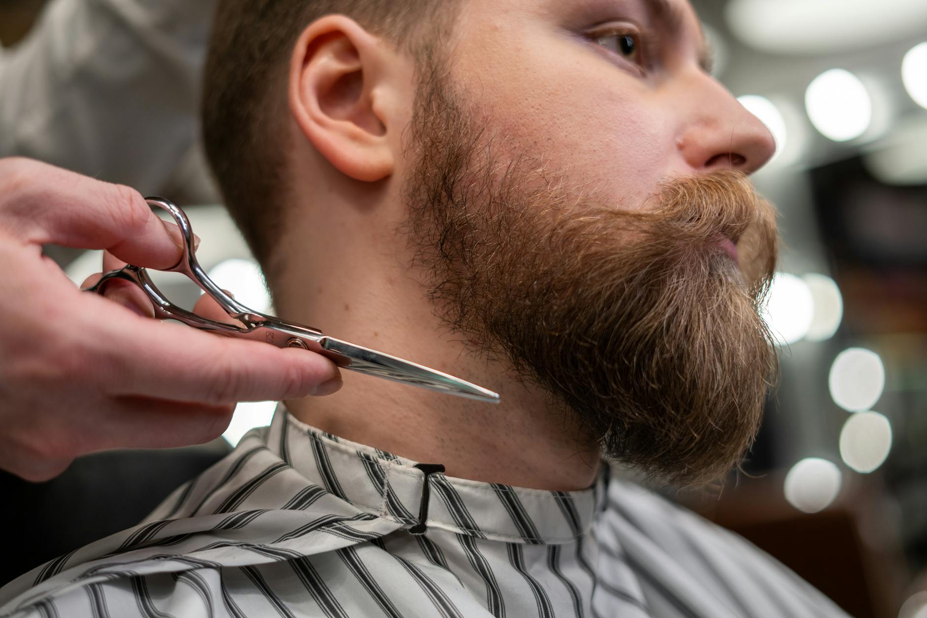 Man looking in mirror applying skincare products as part of daily grooming routine
