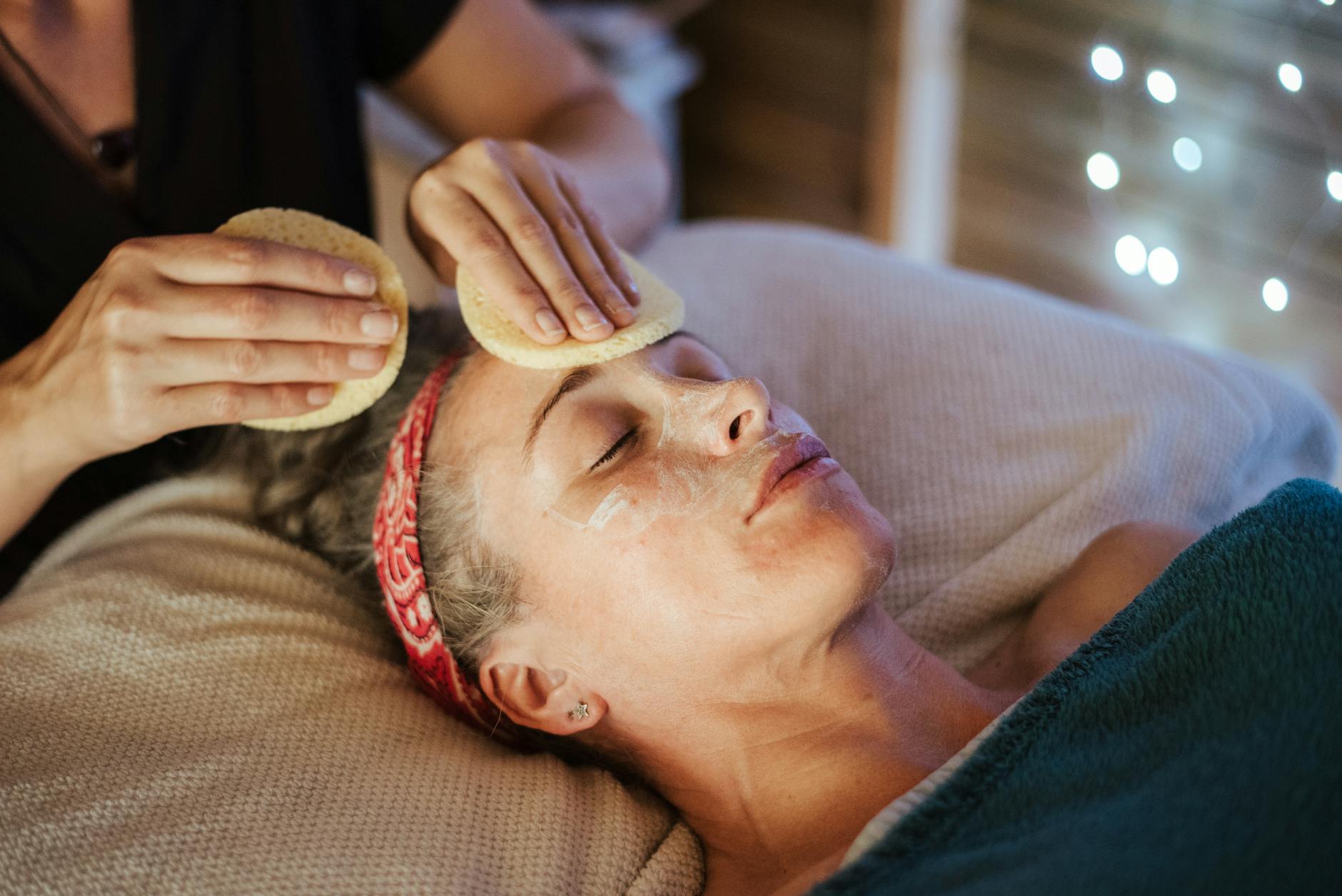 Close-up of hands performing gentle facial therapy treatment on client