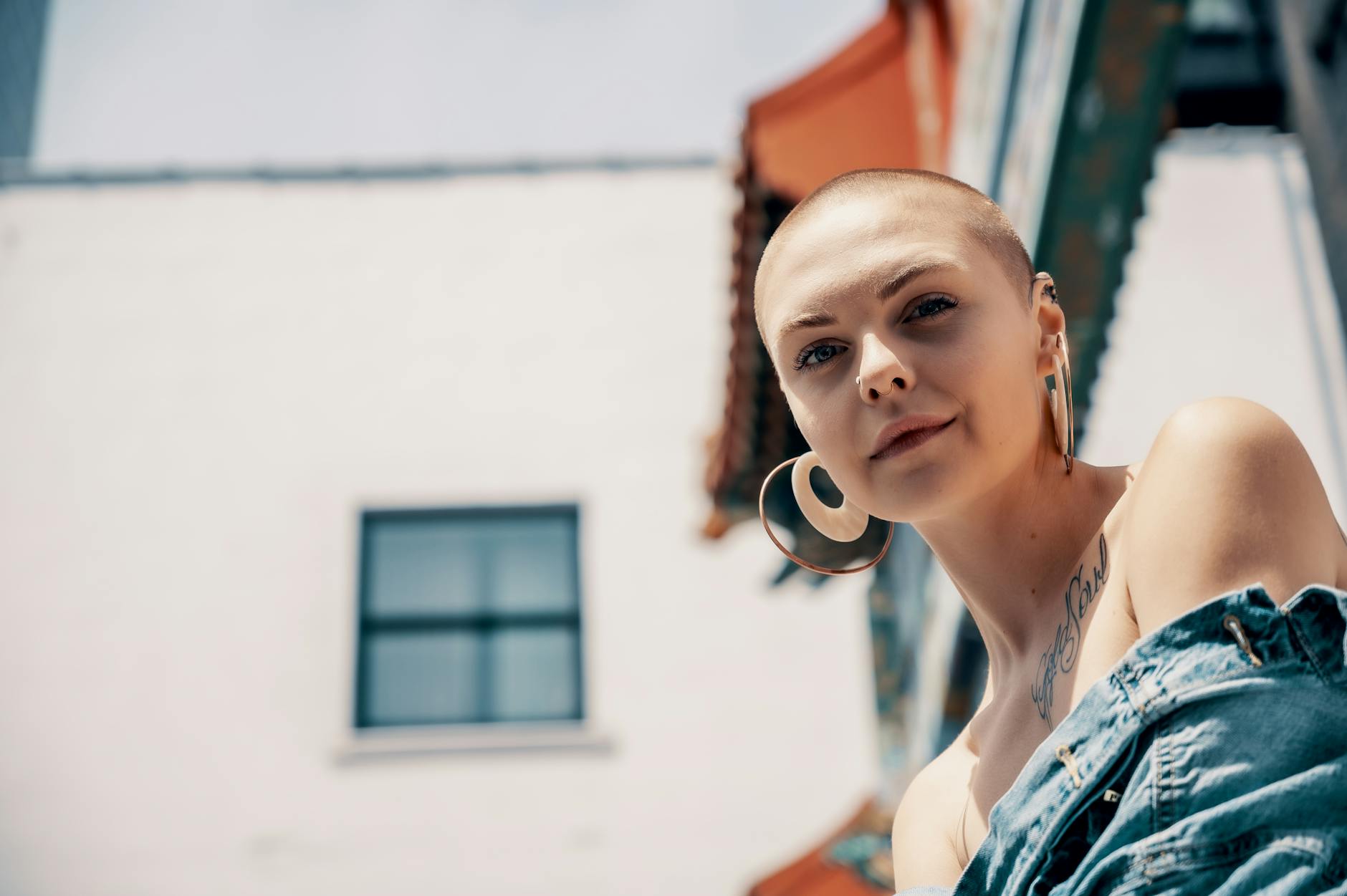 Young woman wearing simple gold hoop earrings and layered necklaces