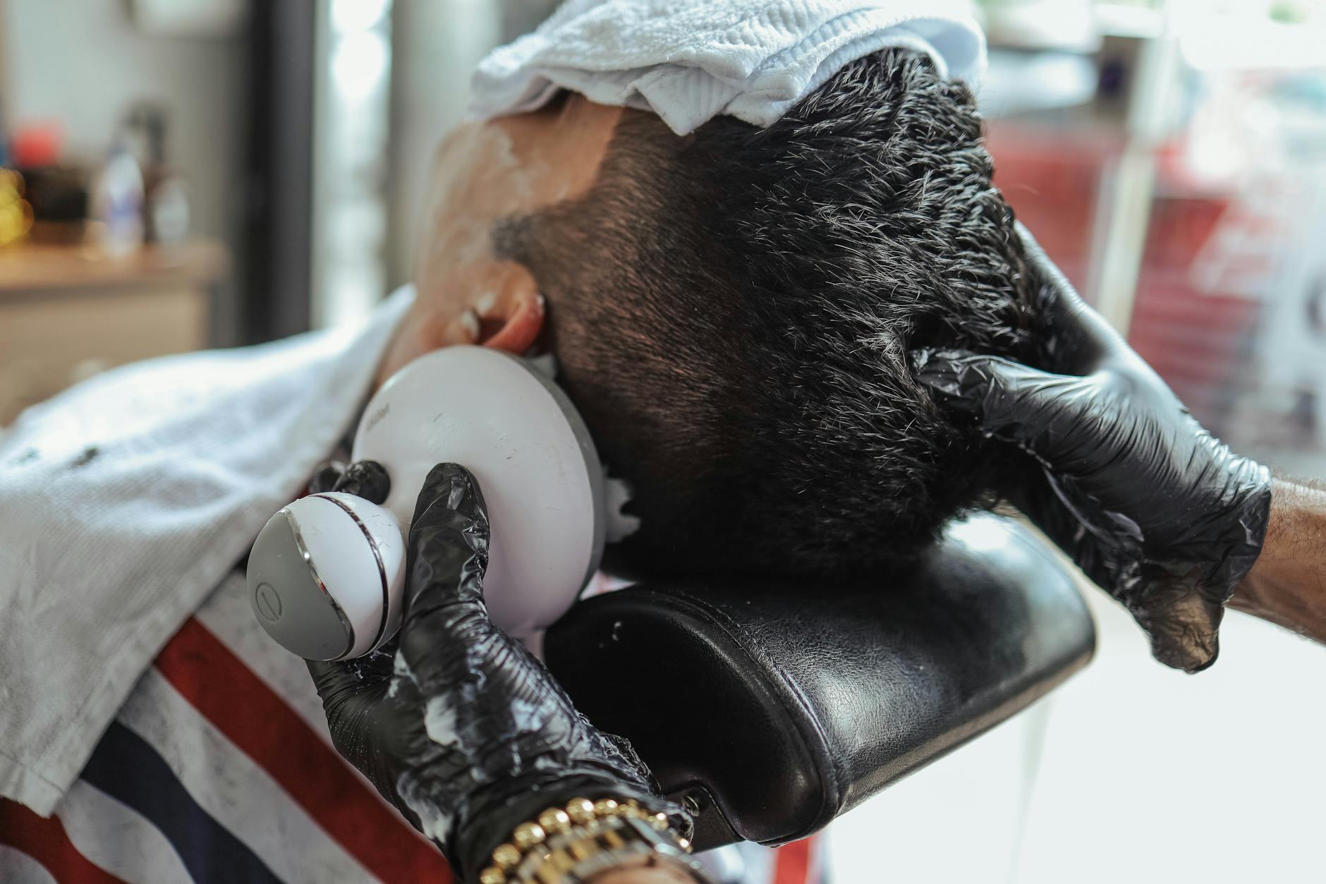 Person receiving scalp massage treatment at spa