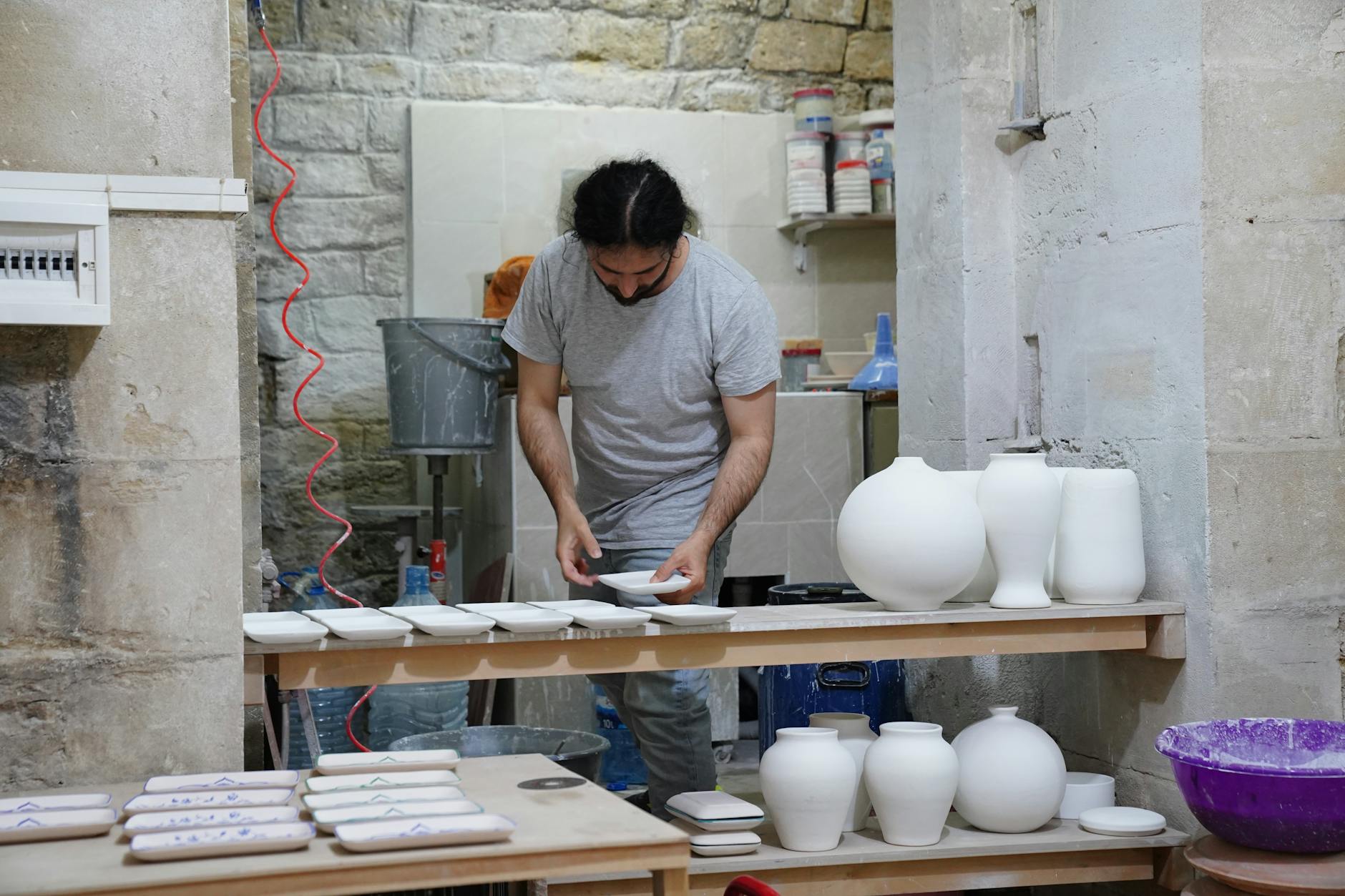 Creative workspace with person in protective apron working on craft project
