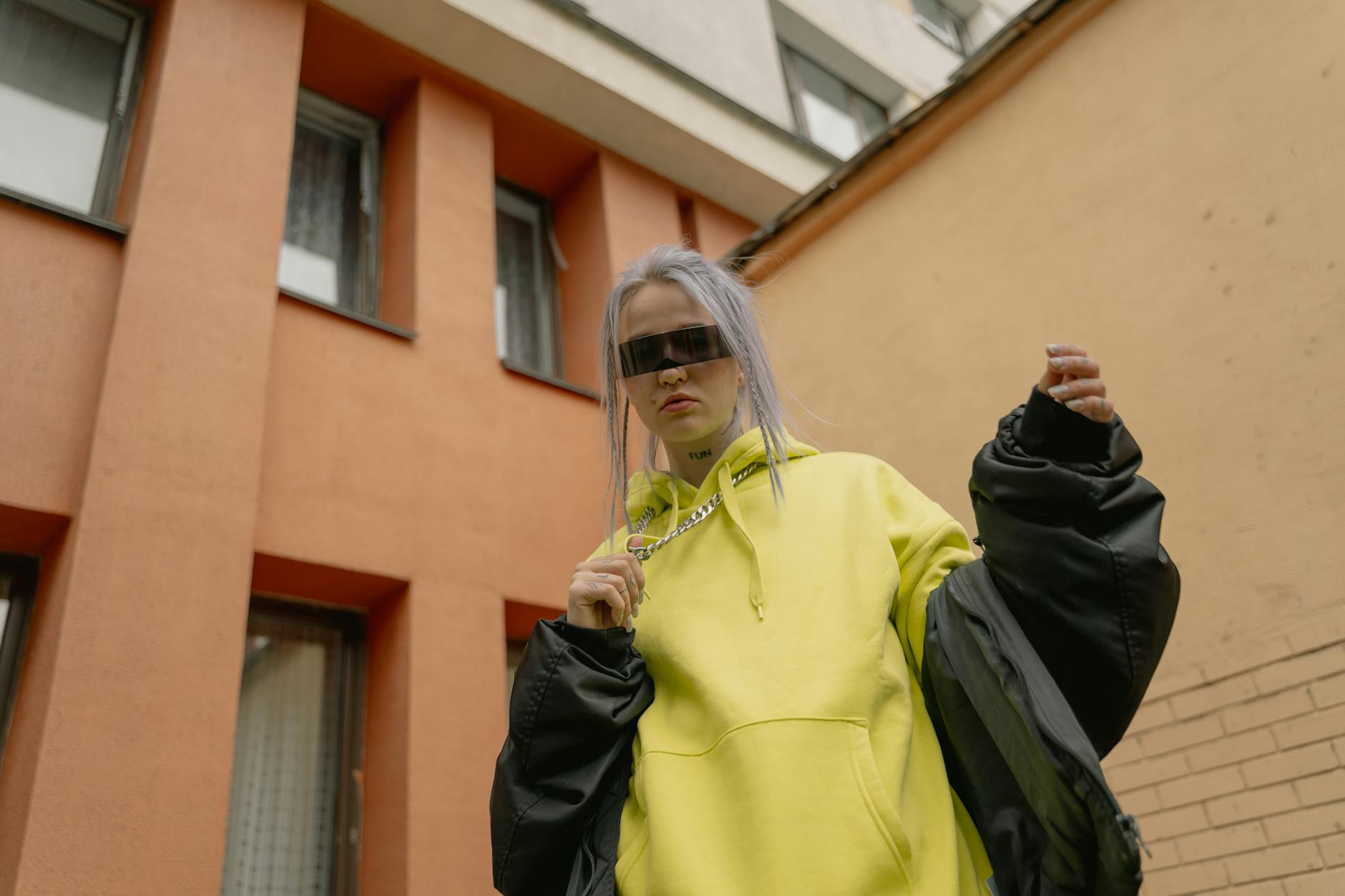 Model wearing a sculptural outerwear jacket on a city street with a minimalist styling