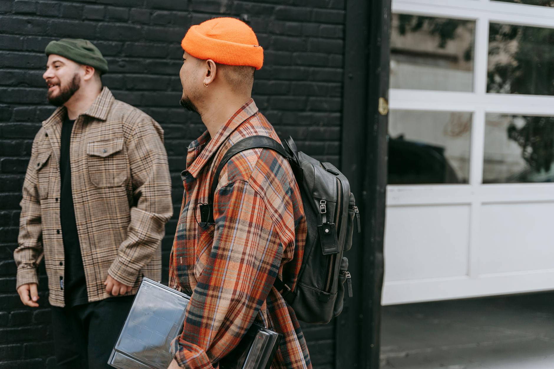 Model wearing layered utilitarian streetwear with leather accessories and canvas vest