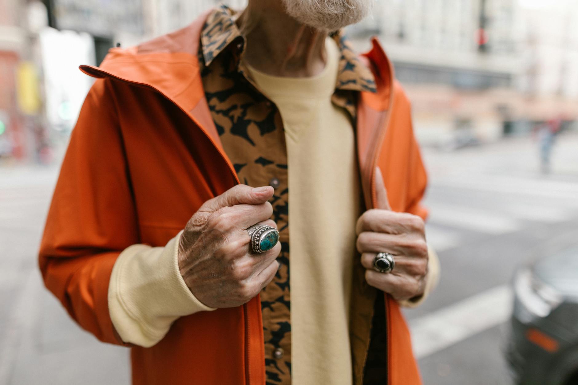 Model wearing a bold athletic jacket over a feminine outfit on a city street