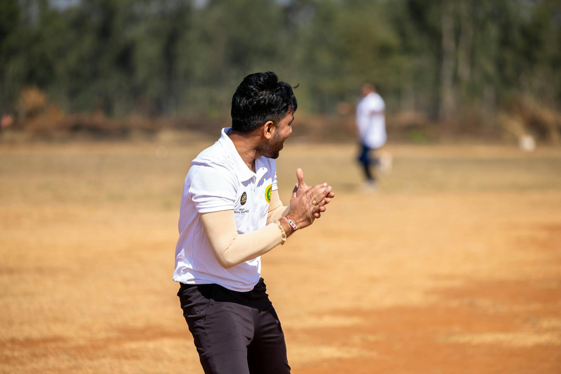 Cricket player in traditional white flannel trousers and V-neck cable-knit sweater