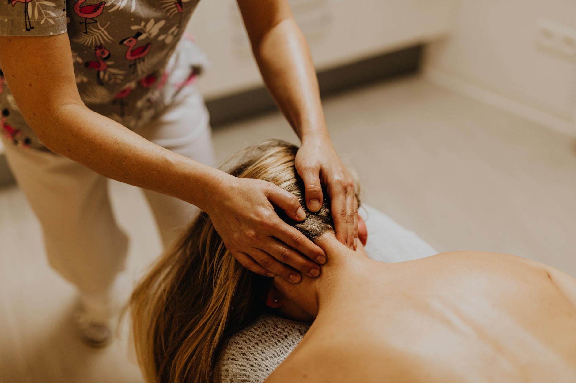 Massage therapist's hands performing facial treatment technique on client