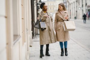 Model wearing a structured wrap coat with wide lapels and belted waist in a minimal fashion setting