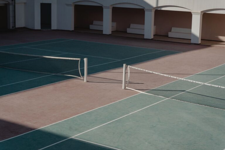 Empty tennis court from elevated angle showing net and baseline markings