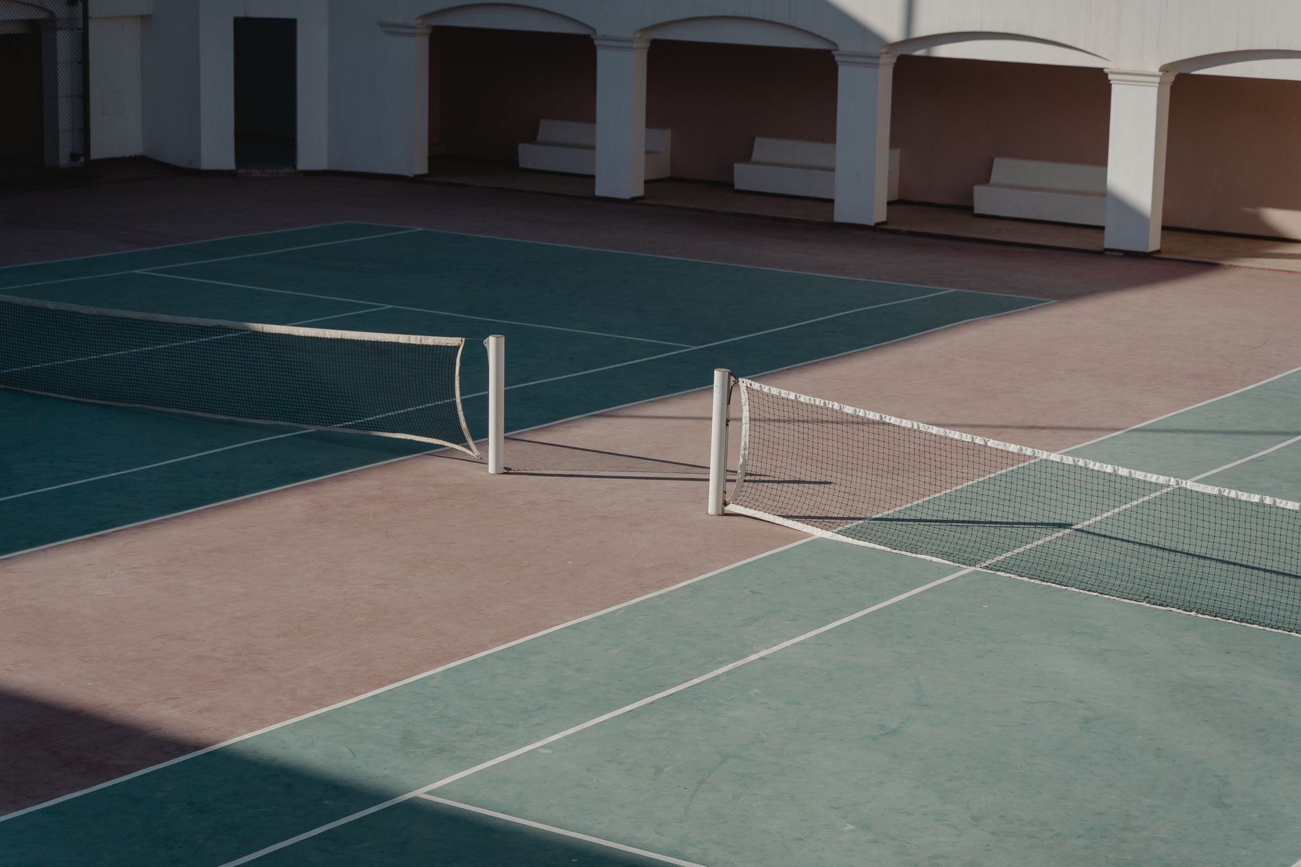 Empty tennis court from elevated angle showing net and baseline markings