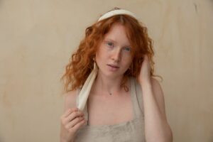 Model wearing relaxed cream linen wide-leg trousers and a collared shirt in a resort setting