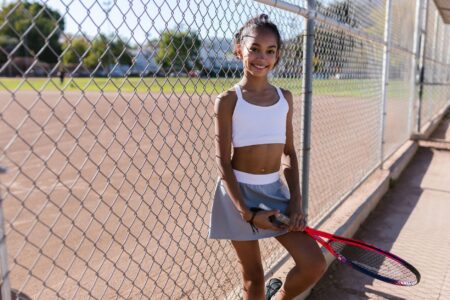 Field Hockey Skorts Are Sliding Into Everyday Athleisure Wardrobes A person wearing a pleated athletic skort outdoors in casual streetwear styling