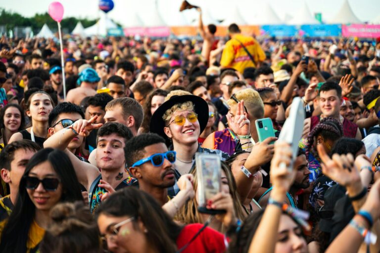 Colorfully dressed festival attendees wearing bold sportswear-inspired outfits at an outdoor music event