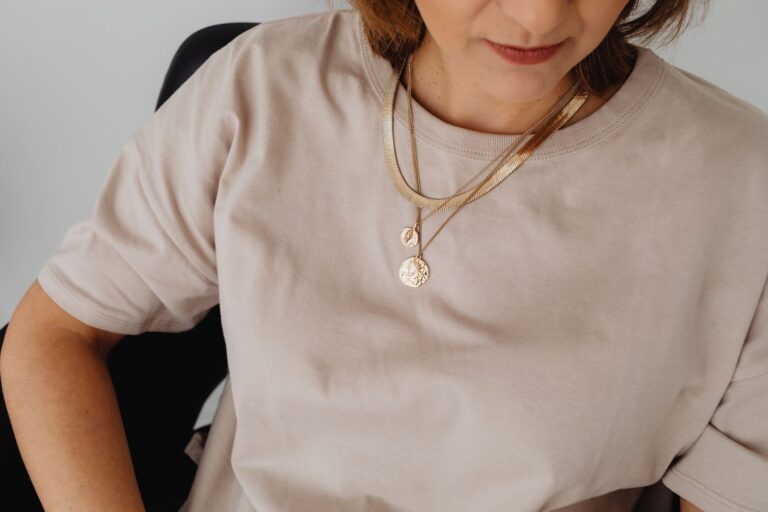 Close-up of minimalist gold arc earrings arranged on a neutral surface