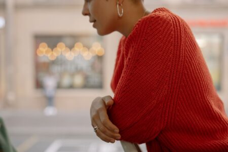 Close-up of a structured knit garment with architectural ribbed texture and open sides
