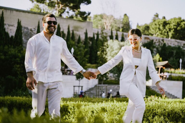 A person wearing a pressed white linen suit in a relaxed summer setting