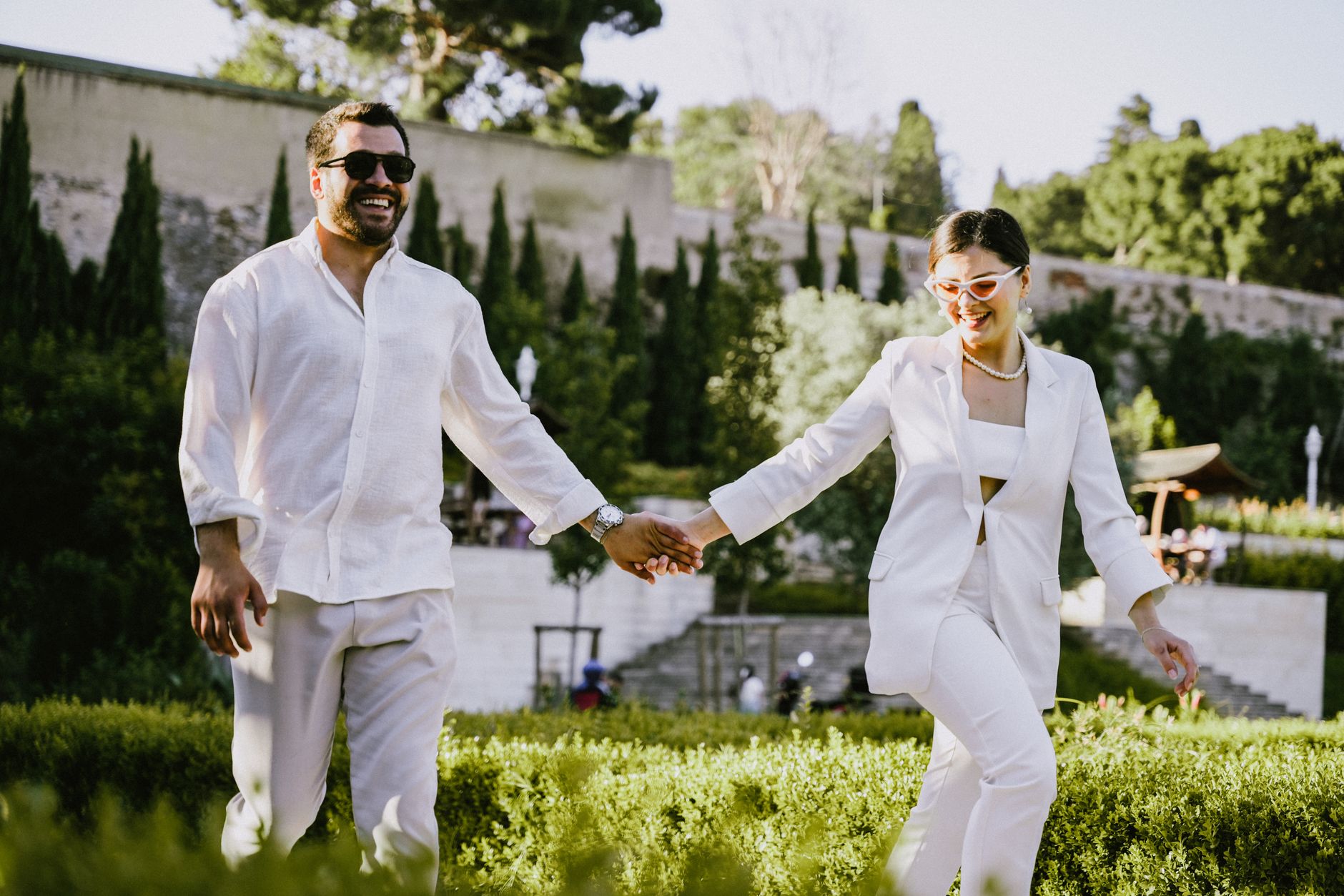 A person wearing a pressed white linen suit in a relaxed summer setting