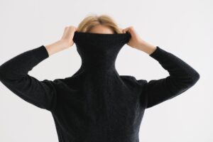 Close-up of structured knit fabric with high polo collar in natural wool tones