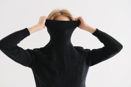 Close-up of structured knit fabric with high polo collar in natural wool tones
