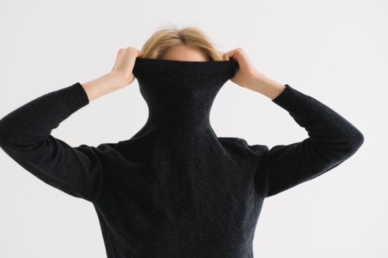 Close-up of structured knit fabric with high polo collar in natural wool tones