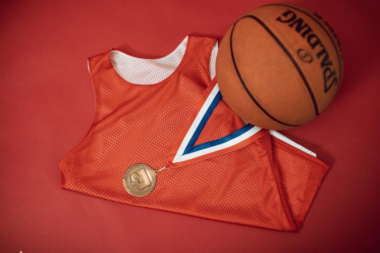 A short athletic jersey dress laid flat on a summer surface, showing colourblocked panels and cap sleeves