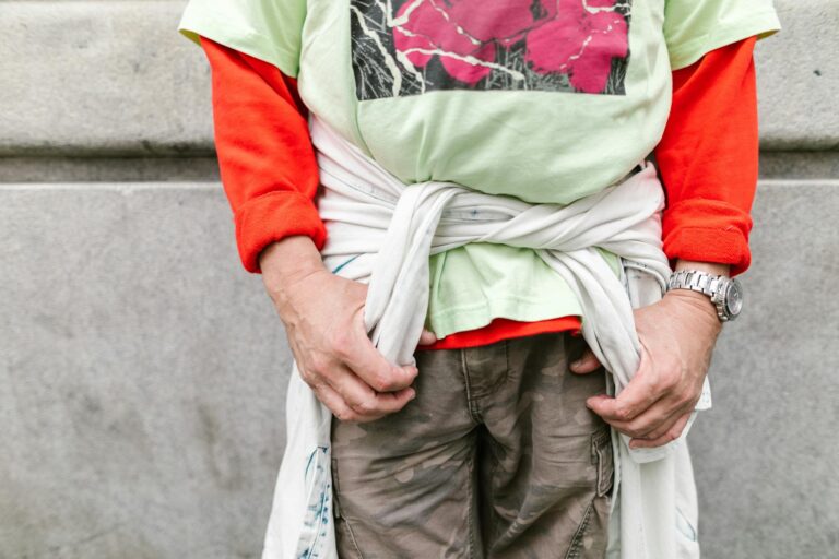 Person wearing layered athletic vest over long sleeve shirt on a city street