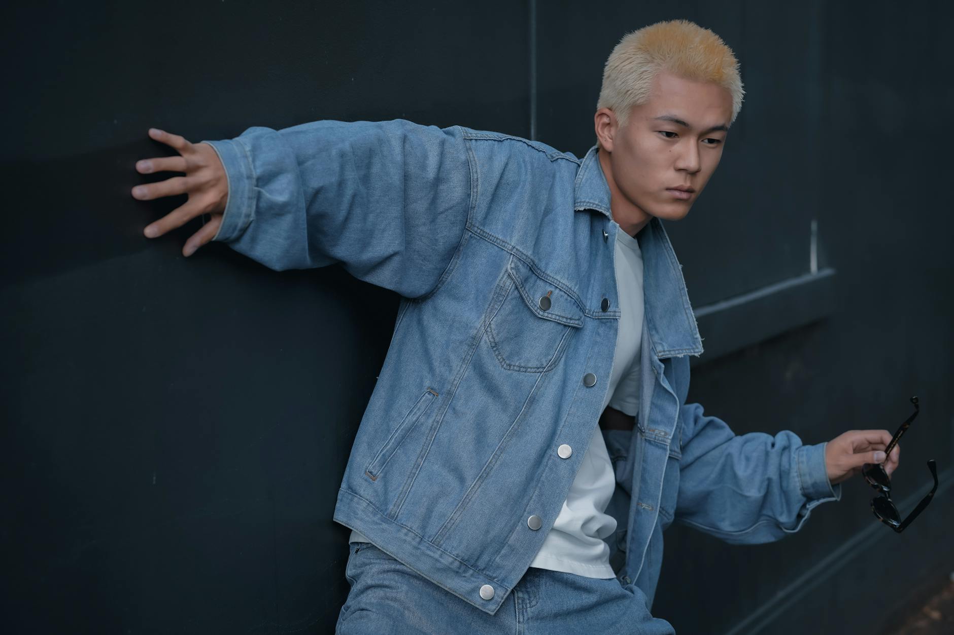 Model wearing oversized streetwear layered outfit with a structured wide belt as the focal accessory