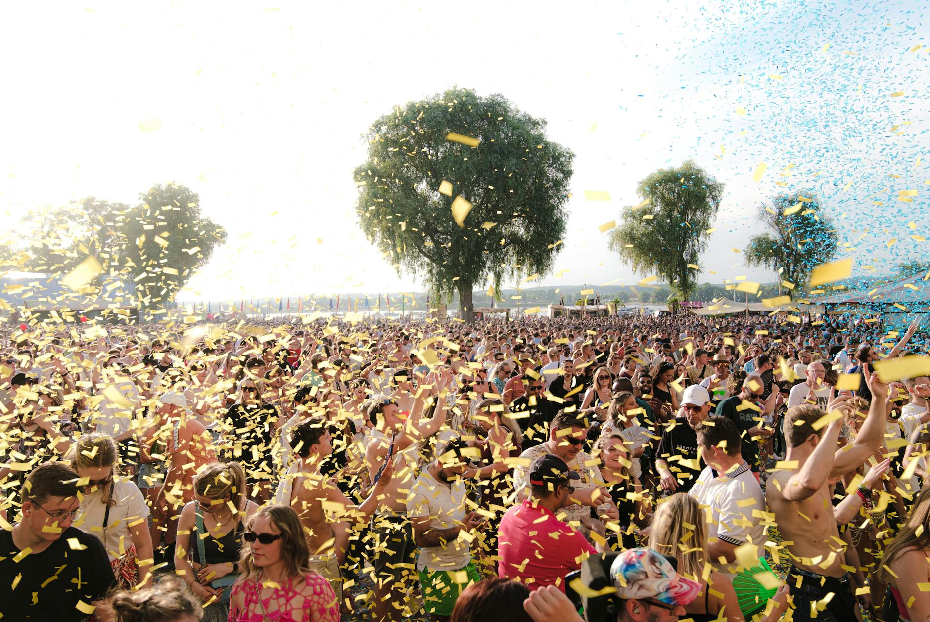 Festival crowd wearing layered athletic and casual outfits at an outdoor music event