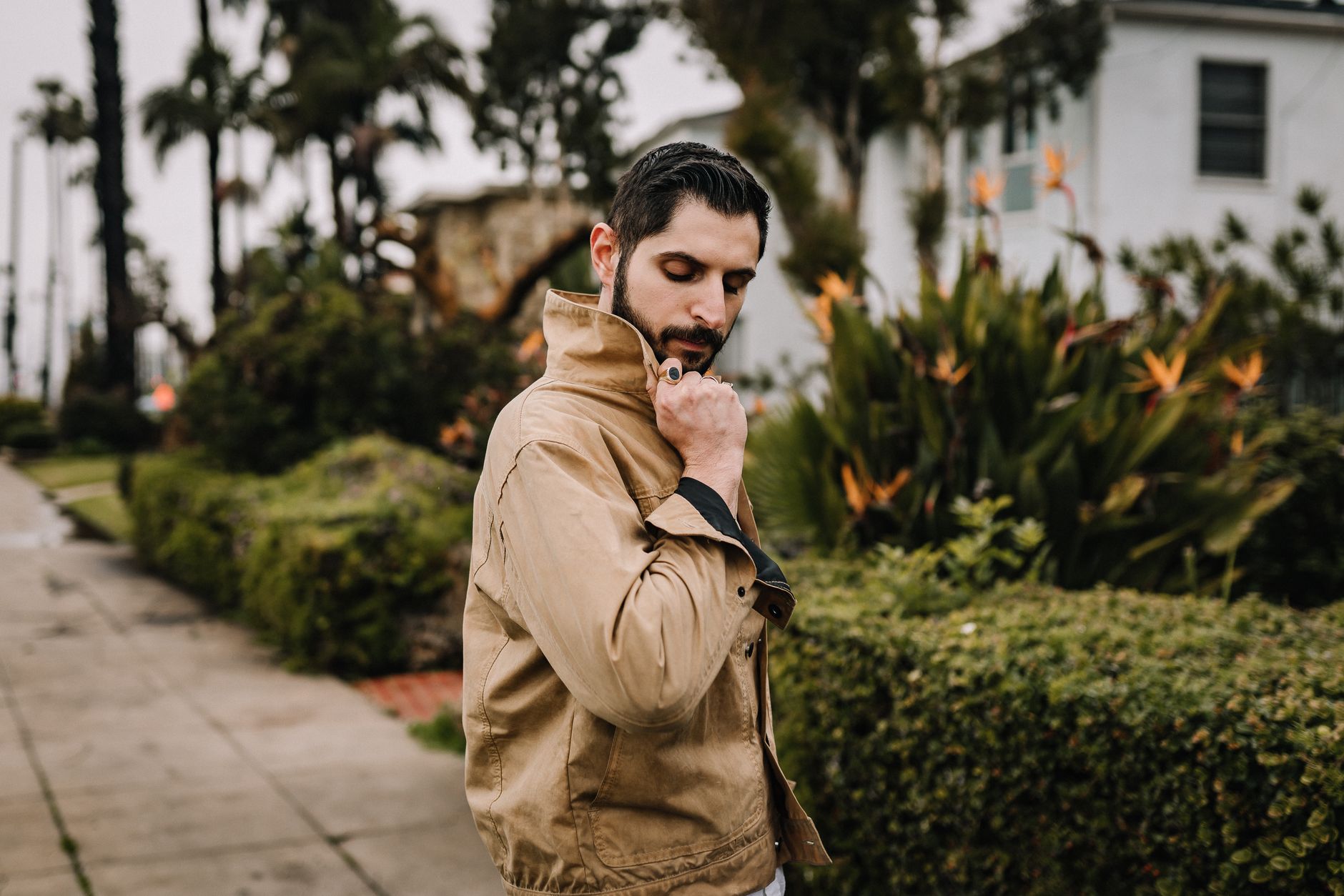 Person wearing a waxed cotton jacket in an urban setting showing material texture