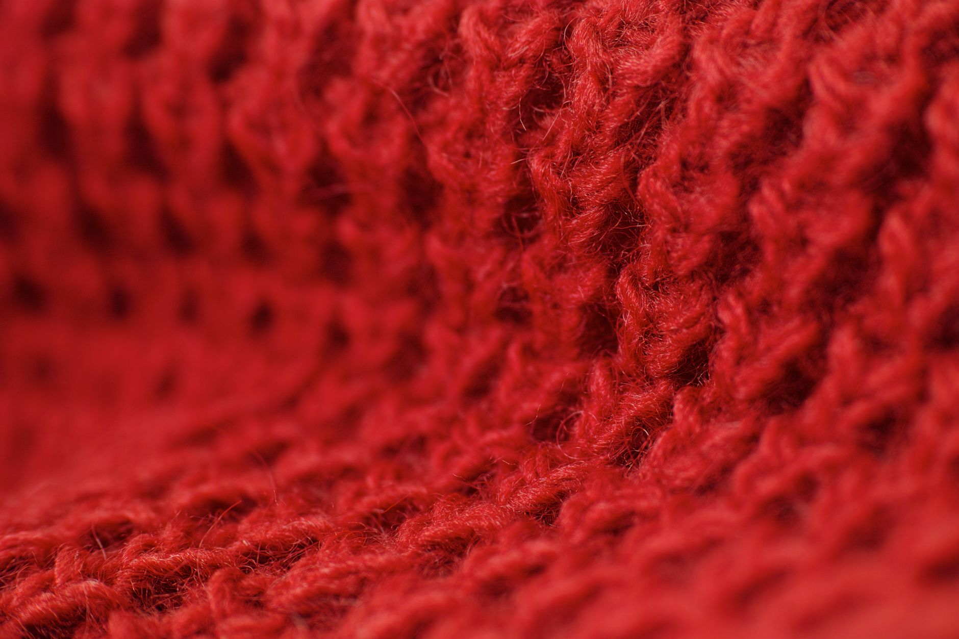A knotted ribbed scarf worn over structured outerwear in a neutral tone